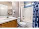 This bathroom features a single sink vanity, toilet, and shower-tub combo with a blue patterned shower curtain at 15022 W Cooperstown Way, Surprise, AZ 85374