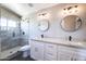 Modern bathroom featuring double sinks, white cabinetry, round mirrors, and tiled walk-in shower at 15039 S 28Th St, Phoenix, AZ 85048