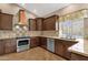 Modern kitchen featuring stainless steel appliances, granite counters, and an accent range hood at 1635 E Silverwood Dr, Phoenix, AZ 85048