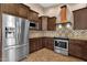 Well-equipped kitchen with a stainless steel refrigerator, gas range, and ample cabinet space at 1635 E Silverwood Dr, Phoenix, AZ 85048