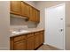 Laundry room features a sink and wood cabinets at 1635 E Silverwood Dr, Phoenix, AZ 85048