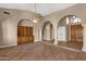 Open-concept living room with tile floors, built-in shelving, and arched columns creating an elegant atmosphere at 1635 E Silverwood Dr, Phoenix, AZ 85048