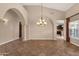 Spacious living room featuring arched doorways, tile floors, and a decorative chandelier at 1635 E Silverwood Dr, Phoenix, AZ 85048