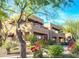 A beige southwestern style home featuring balconies, awning accents, and xeriscaped front yard at 16657 E Gunsight Dr # 233, Fountain Hills, AZ 85268