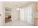 Bright dining area adjacent to the kitchen with white tile flooring, and chandelier at 18034 N 129Th Ave, Sun City West, AZ 85375