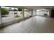 Enclosed patio features neutral tile flooring and windows overlooking the gravel yard at 18034 N 129Th Ave, Sun City West, AZ 85375