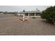 Home exterior showcases a gravel yard with brick accents and green shrubs at 18034 N 129Th Ave, Sun City West, AZ 85375