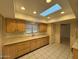 Bright kitchen featuring a skylight, tile flooring, and plenty of storage space at 18034 N 129Th Ave, Sun City West, AZ 85375