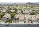 Aerial view of a desert community featuring tile roofs, green golf course, and mountain views at 1835 E Brookwood Ct, Phoenix, AZ 85048