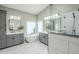 Bright bathroom featuring dual vanities, soaking tub under a window, and glass-enclosed shower with tile surround at 1835 E Brookwood Ct, Phoenix, AZ 85048