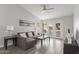 Bright living room with vaulted ceilings, ceiling fan, and a gray sectional sofa with a gray wood floor at 2035 S Elm St # 217, Tempe, AZ 85282