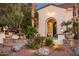 Inviting front entrance featuring a beautiful fountain, lush greenery, and a charming arched doorway at 22329 N Padaro Dr, Sun City West, AZ 85375