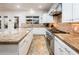 Bright kitchen with granite countertops, stainless steel appliances, tiled backsplash, and a view of the outdoor pool at 22329 N Padaro Dr, Sun City West, AZ 85375