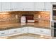 Modern kitchen with white cabinets, granite countertops, and tile backsplash at 22329 N Padaro Dr, Sun City West, AZ 85375