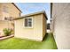 A backyard shed with a window, beige siding, and some bushes on faux grass at 22462 N 80Th Ln, Peoria, AZ 85383