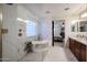 Luxurious bathroom featuring a soaking tub, walk-in shower, marble accents and views into the primary bedroom at 22927 N 41St St, Phoenix, AZ 85050