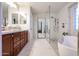 Bright, updated bathroom featuring marble floors, a glass shower, and a freestanding tub at 22927 N 41St St, Phoenix, AZ 85050