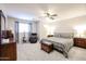 Spacious bedroom with a ceiling fan, an area rug, a mirror, and a comfortable seating area at 22927 N 41St St, Phoenix, AZ 85050