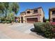 Two-story stucco home featuring a two-car garage, tile roof, arched entry, and landscaped front yard at 22927 N 41St St, Phoenix, AZ 85050