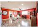 Spacious entertainment room boasts hardwood floors, two white recliners, and bright, red walls at 22927 N 41St St, Phoenix, AZ 85050