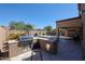 Outdoor kitchen with built-in grill, bar, and seating area overlooking the pool and covered patio at 22927 N 41St St, Phoenix, AZ 85050