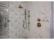 Shower featuring a large shower head and hand wand with marble and leaf-patterned tile walls at 22927 N 41St St, Phoenix, AZ 85050