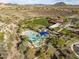 Aerial view of community amenities including pool, clubhouse, lawn, and parking, surrounded by desert landscape at 29412 N 128Th Ln, Peoria, AZ 85383