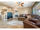 Cozy living room with a fireplace, large TV, comfortable seating, and neutral decor at 29412 N 128Th Ln, Peoria, AZ 85383
