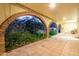 Charming outdoor patio with brick arches, tile flooring, and lush landscaping offering a serene retreat at 3101 E Acoma Dr, Phoenix, AZ 85032