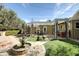 Beautiful backyard featuring a stone fountain, lush artificial turf, outdoor dining under a pergola and manicured landscaping at 34 W Vernon Ave, Phoenix, AZ 85003