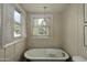 Bathroom showcasing a vintage clawfoot tub, and natural light from the window, creating a bright, relaxing space at 34 W Vernon Ave, Phoenix, AZ 85003