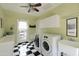 Well-lit laundry room featuring checkerboard floors, modern washer and dryer, sink, and ample storage cabinets at 34 W Vernon Ave, Phoenix, AZ 85003