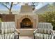 Cozy outdoor fireplace with striped chairs providing a warm and inviting atmosphere for outdoor living at 34 W Vernon Ave, Phoenix, AZ 85003