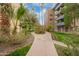 Curved walking path on the community grounds, with palm trees and lush landscaping at 351 E Thomas Rd # E106, Phoenix, AZ 85012