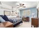 Cozy bedroom featuring a ceiling fan, blue accent wall and ample natural light from the window at 3511 N Miller Rd, Scottsdale, AZ 85251