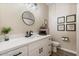 Well-lit bathroom with white cabinets, countertop, framed art, and modern fixtures at 3716 E Andre Ave, Gilbert, AZ 85298
