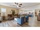Open-concept living room with hardwood floors, ceiling fan, and easy access to a bright modern kitchen and dining area at 3716 E Andre Ave, Gilbert, AZ 85298