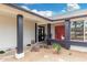 Inviting front porch with stone accents, a red entry door, and drought-tolerant landscaping at 3973 W Hearn Rd, Phoenix, AZ 85053