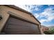 Close up view of a brown garage door on a sunny day at 40433 W Hensley Way, Maricopa, AZ 85138