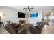 Comfortable living room features a ceiling fan, wall-mounted TV, and reclining sofa at 40433 W Hensley Way, Maricopa, AZ 85138