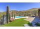 Inviting kidney shaped pool and spa with desert mountain views, lush turf, and lounge seating at 40445 N 32Nd St, Cave Creek, AZ 85331