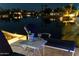 Serene poolside lounge featuring a wine bucket and picturesque water views at night at 435 E Coconino Pl, Chandler, AZ 85249