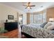 Bright bedroom features wood floors, ceiling fan, patio access, and windows with plantation shutters at 4709 E Blue Spruce Ln, Gilbert, AZ 85298