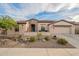 Charming home featuring desert landscaping, rock accents, and a spacious two-car garage at 4709 E Blue Spruce Ln, Gilbert, AZ 85298