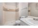 Bathroom featuring a walk-in shower, tiled walls, toilet, and sink at 4813 N 62Nd Ave, Phoenix, AZ 85033