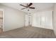 Neutral bedroom featuring a closet with sliding doors, carpet, and a ceiling fan at 4813 N 62Nd Ave, Phoenix, AZ 85033