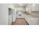 Kitchen featuring white cabinets, tile floor, and white appliances at 4813 N 62Nd Ave, Phoenix, AZ 85033