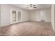 Open living area with tile flooring and French doors leading to outdoor space, complemented by a modern ceiling fan at 4813 N 62Nd Ave, Phoenix, AZ 85033