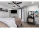 Cozy bedroom featuring a four-poster bed, ceiling fan, TV, and vanity area at 5030 S 23Rd Ave, Phoenix, AZ 85041