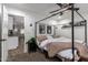 Inviting bedroom featuring a four-poster bed, soft carpet, and a peek into the modern kitchen at 5030 S 23Rd Ave, Phoenix, AZ 85041